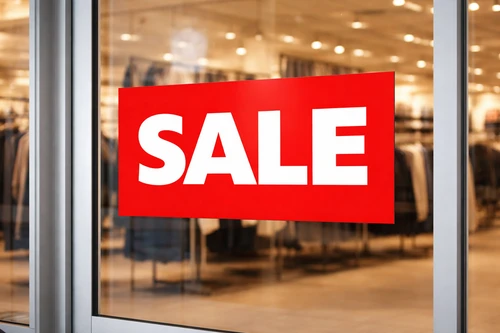 Red “SALE” poster affixed to a shop window