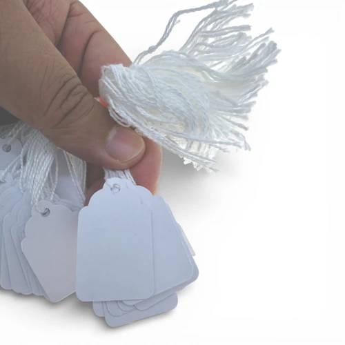 White Strung Parcel Tags with Cotton String, product shown against a coloured background
