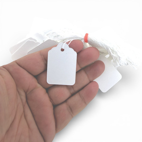 White Strung Parcel Tags with Cotton String, product shown against a coloured background, balanced, centred square layout