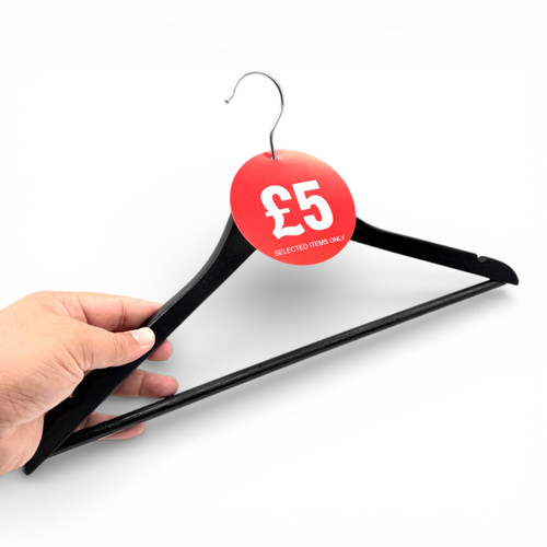 Hand holding a black clothes hanger with a red £5 ticket