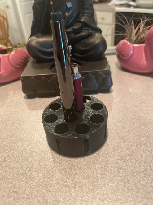 Kush Kitteh The PUCK XL 3D-printed circular desktop organizer stand in Black with wide 15mm cartridge slots, shown in a clean desktop environment.