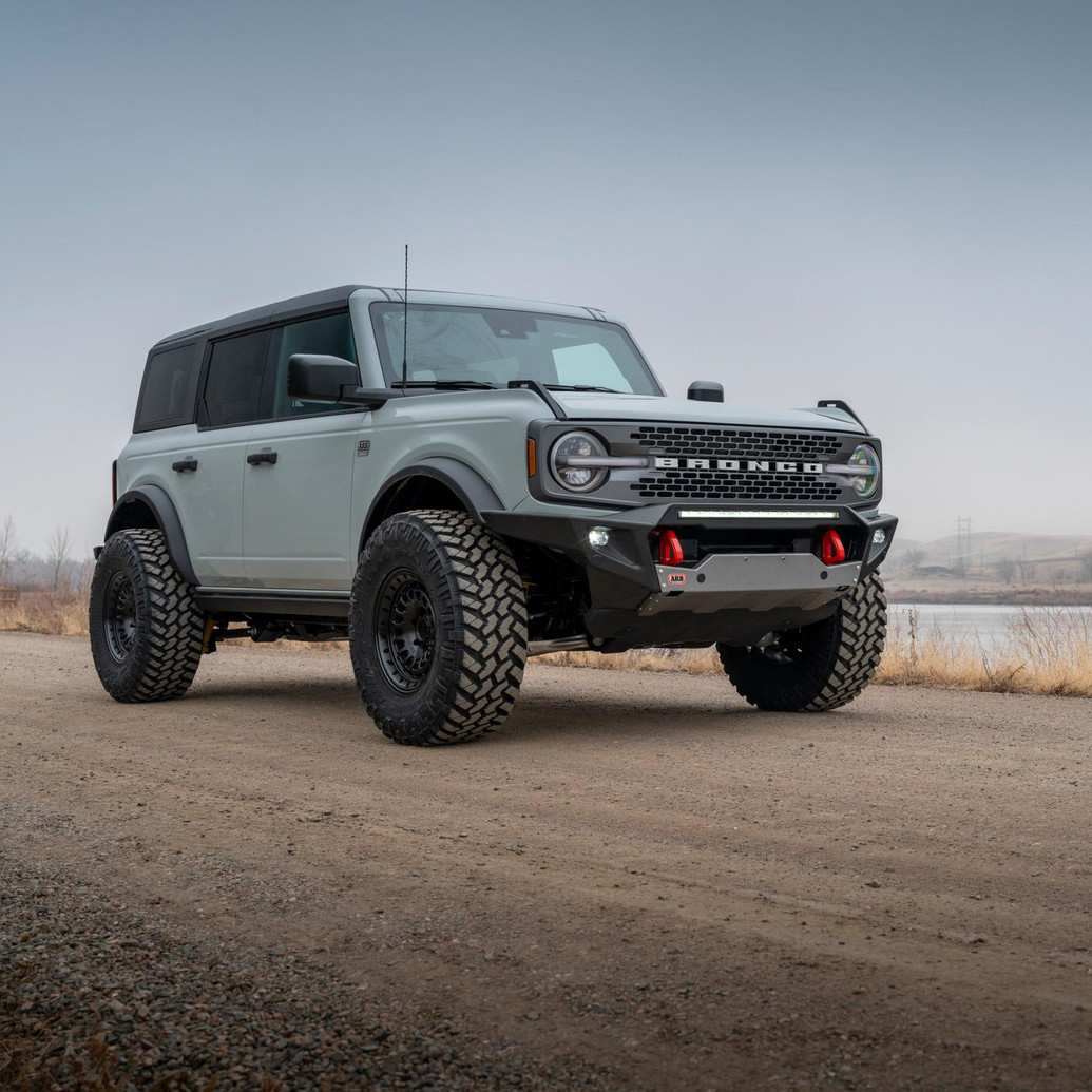ARB Non-Winch Front Bumper 3280010B, black off-road bumper with recovery points and integrated lights installed on a gray Ford Bronco