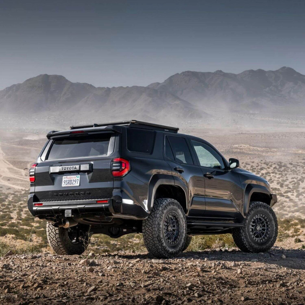 Old Man Emu MT64 Suspension Kit w/FB UCA for 4Runner (2025+), front 3-inch lift and rear suspension, off-road vehicle on rocky terrain with mountainous background.