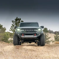 ARB Non-Winch Front Bumper 3280010B, rugged black off-road bumper with silver skid plate fitted to the front of a Ford Bronco in a grassy outdoor setting.