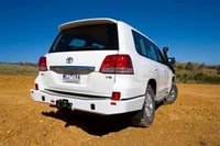 ARB Rear Bumper 5615020B, white vehicle rear view on dirt terrain with clear blue sky.