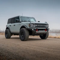 ARB Non-Winch Front Bumper 3280020B, black off-road bumper with integrated lights and red recovery points mounted on a gray Ford Bronco