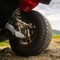 Old Man Emu BP-51 3 inch Lift Kit with UCA for Toyota Tacoma 2024+ model, front view showing suspension components and large off-road tire on rocky terrain.