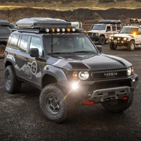 Old Man Emu BP-51 Kit FR 3 in/0-330 lb, RR 2 in/880 lb 2219K, off-road vehicle suspension kit installed on a rugged off-road Toyota SUV with additional four vehicles in the background, outdoor environment with rugged terrain.