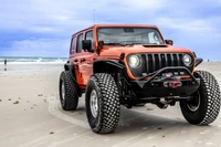 Poison Spyder Front JL/JT CRUSHER Flares (Black), off-road vehicle with rugged tires on a sandy beach.