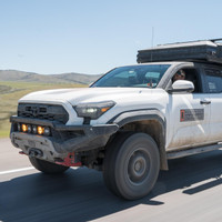 ARB Zenith Winch Bumper for Toyota Tacoma (2024+), mounted on a rugged off-road vehicle during a drive on open terrain.