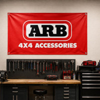 ARB Shop Vinyl Banner 5'x3' 570193US, red vinyl banner with ARB logo and 4x4 Accessories text displayed on workshop wall.