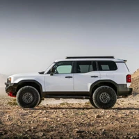 Old Man Emu MT64 Suspension Kit w/FB UCA for Land Cruiser, front view of a white 2024+ Land Cruiser SUV with upgraded suspension features in a desert landscape.
