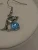 Silver-tone Dolphin Dangle Earring Feature a Blue Stone and Small Crystals