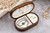 Open walnut jewelry box with soft white velvet lining, ring holders and compartments for storing necklaces, earrings and bracelets.