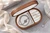 Top view of an oval walnut jewelry box with personalized name engraving and botanical flower design on the polished wooden lid.