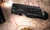 Personalized black folding pocket knife showing open blade, engraved handle and metal pocket clip.