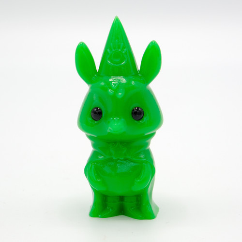 A solid green figurine on an animal wearing a hat and cape