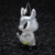 A silver animal figurine wearing a black hat
