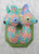 A two-headed mounted animal head sculpture on an aqua plaque