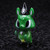 A  green animal figurine wearing a black hat