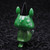 A  green animal figurine wearing a black hat