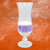 Drinking glass with a purple design printed on it.