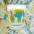 Drinking glass with characters printed on it. Glass is on a floral pattern backdrop.