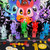 Multicolored figurines of animals wearing hats and capes in front of an illustration of multicolored characters