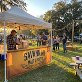 Custom tent half wall across a brewery owner's ten foot canopy at a golden hour festival.