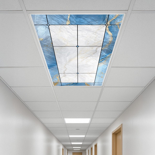 Modern office hallway with a decorative ceiling panel featuring a blue and white marble design accented with gold, surrounded by standard fluorescent light panels.