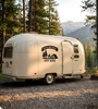 Campsite decal with your family name on a banner over a tent, campfire and pines applied outdoors
