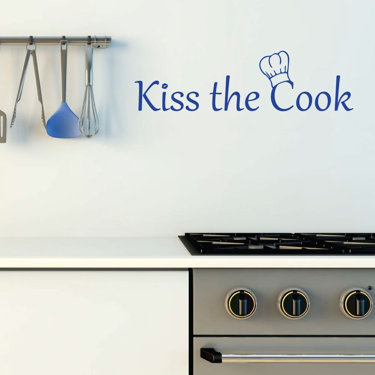 Kiss The Cook vinyl wall decal in a kitchen with hanging utensils above the stove