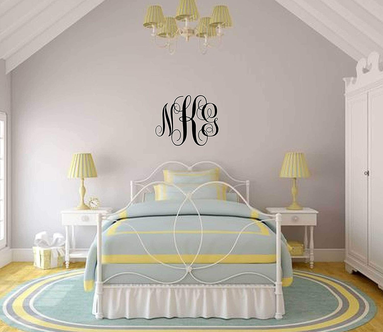 Personalized monogram initials wall decal above a bed in a bright vaulted bedroom