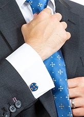Man wearing a patonce cross blue tie and matching cufflinks