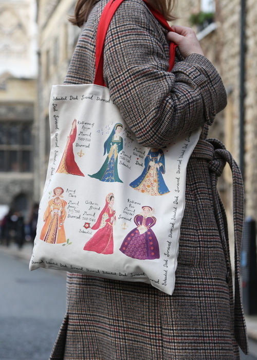 A woman holding a bag showing Henry VIIIs and his six wives