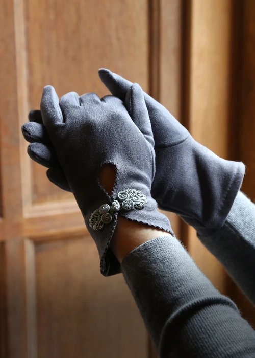 A woman in a pair of grey gloves
