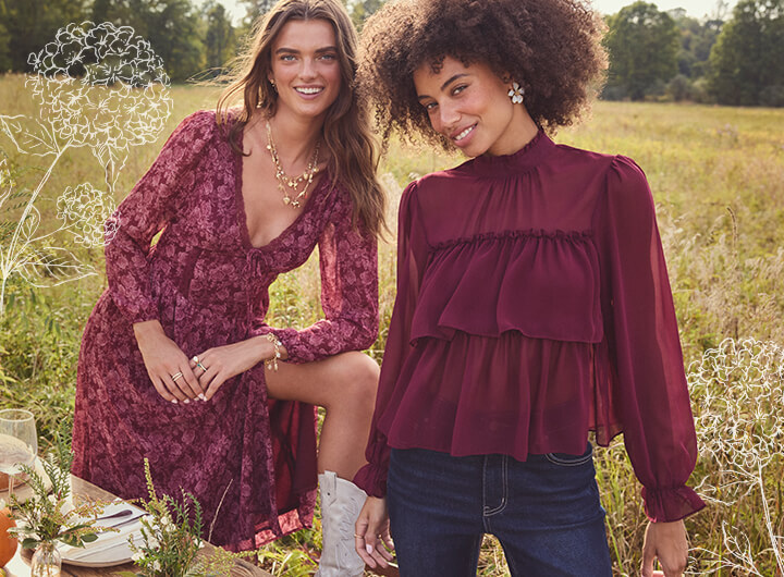This image shows two girls in a field wearing burgundy clothing.