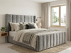 "A luxurious grey velvet bed frame featuring a tall, winged headboard with elegant fluted detailing."