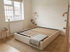 Cream velvet bed frame with no mattress, displaying the internal solid wooden slats and a sturdy centre support bar.