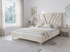 The luxurious Sequoia Upholstered Bed Frame in warm cream velvet fabric, showcasing its modern geometric headboard with a striking V-shaped inlay and cohesive, fully upholstered footboard