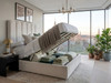 Cream velvet Bella Bubble Ottoman bed with the mattress platform lifted, displaying the full-sized, front-opening storage area and sturdy internal solid base boards