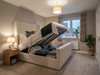 Off-white velvet ottoman bed frame lifted open by gas hydraulics, revealing the spacious under-bed storage compartment.