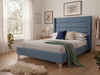 Midnight blue linen Micaela upholstered bed frame, acting as a striking modern centerpiece with tailored side rails and deep fluted horizontal panels.