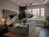 Grey velvet Anette Ottoman Bed shown open with gas-lift mechanism, revealing spacious under-bed storage and solid base boards