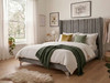 The Lovis upholstered bed frame finished in a luxurious grey velvet, featuring a tall winged headboard with deep fluted vertical lines.