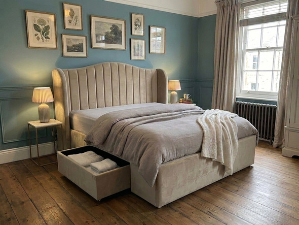 Vendela upholstered linen bed frame in warm beige, showcasing a modern rustic fluted winged headboard and a spacious jumbo storage drawer on castors.