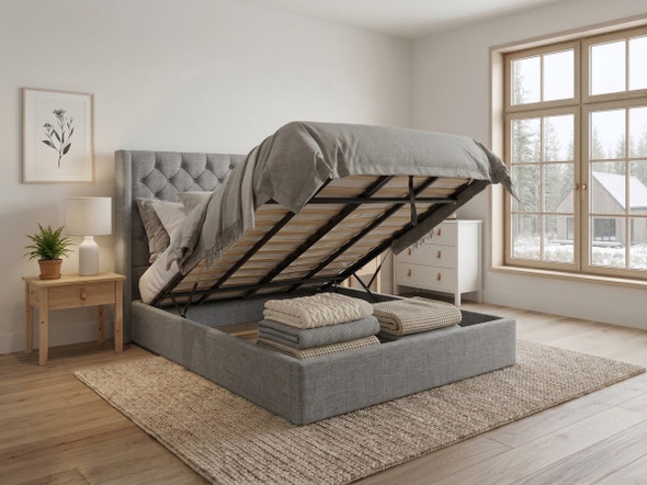 Functional ottoman storage bed in silver smooth velvet, with the mattress base lifted by hydraulic gas struts to reveal the expansive underbed storage area and internal frame.