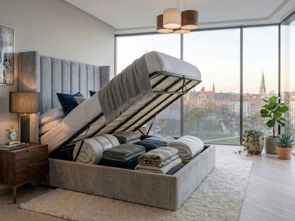 Adele Ottoman Storage Bed Frame in grey velvet, shown with the front-opening gas-lift base raised to reveal the spacious under-bed storage compartment and solid base boards.