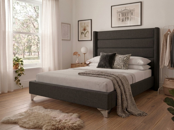 Dark charcoal linen Micaela upholstered bed frame featuring a tall, fluted wingback headboard, showcasing premium West Midlands craftsmanship