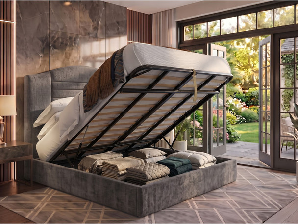 Haven Ottoman Storage Bed Frame in Steel grey Atlanta fabric, shown open to reveal the under-bed storage area, with the distinctive curved and fluted headboard in the background.